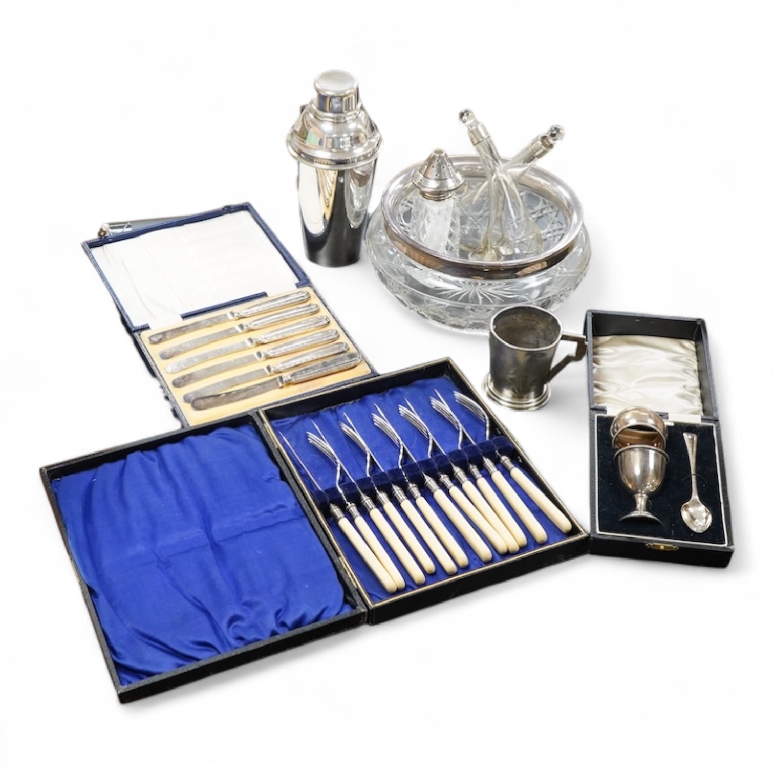 A silver christening mug, Birmingham, together with three cased sets, silver rimmed cut glass bowl, plated cocktail shaker etc
